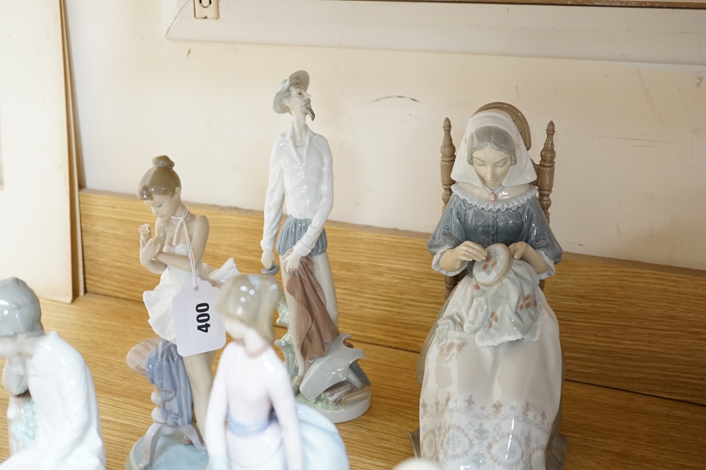Ten Lladro figures including Don Quixote and seated lady with embroidery, the largest 30cm high
